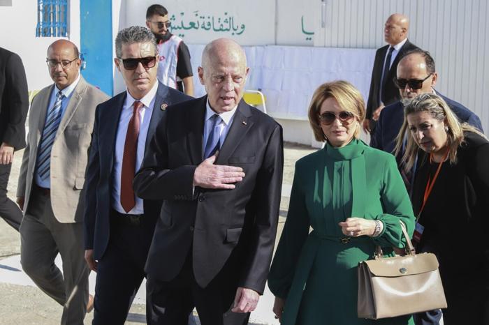 Il presidente tunisino e candidato alla rielezione Kais Saied, al centro, e sua moglie Ichraf Chebil Saïed, lasciano un seggio elettorale dopo il voto a Tunisi. Foto Anis Mili / Ap /LaPresse kais-saied-urne-elezioni-tunisia-lapresse