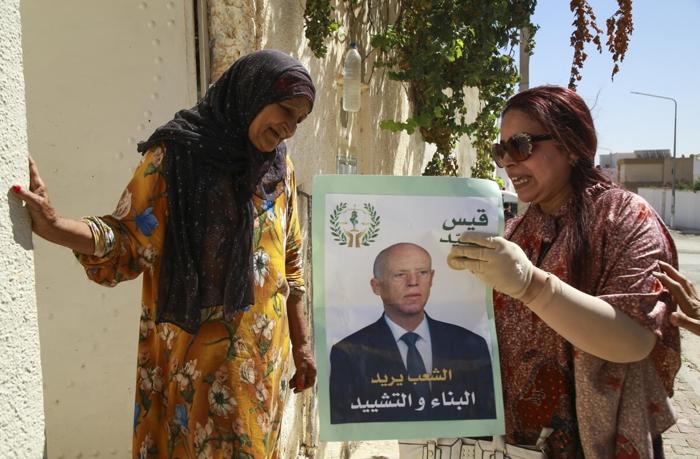 Una sostenitrice del presidente tunisino e candidato alla rielezione Kais Saied incontra i residenti di un quartiere durante un tour della campagna elettorale ad Ariana, in Tunisia. Foto Anis Mili / AP /LaPresse tunisia-elezioni-saied-lapresse