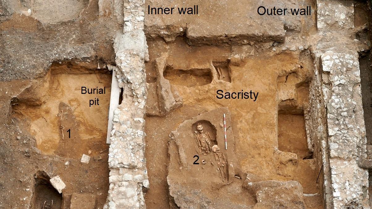 una veduta aerea di uno scavo con mura e la fossa funeraria in cui fu collocato un sarcofago romano