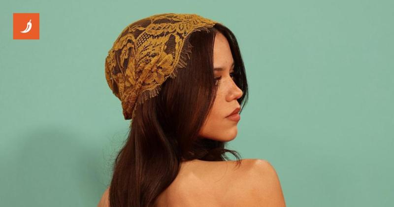 Jenna Ortega sorprende con un abito dorato e una cuffietta di pizzo