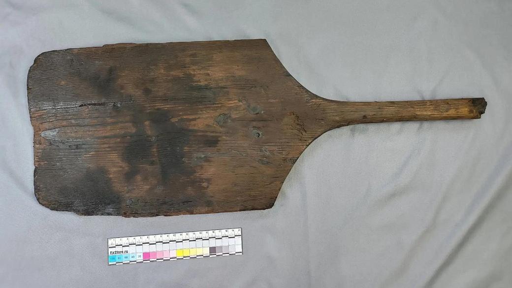 una paletta di legno piatta e rettangolare con il manico spezzato