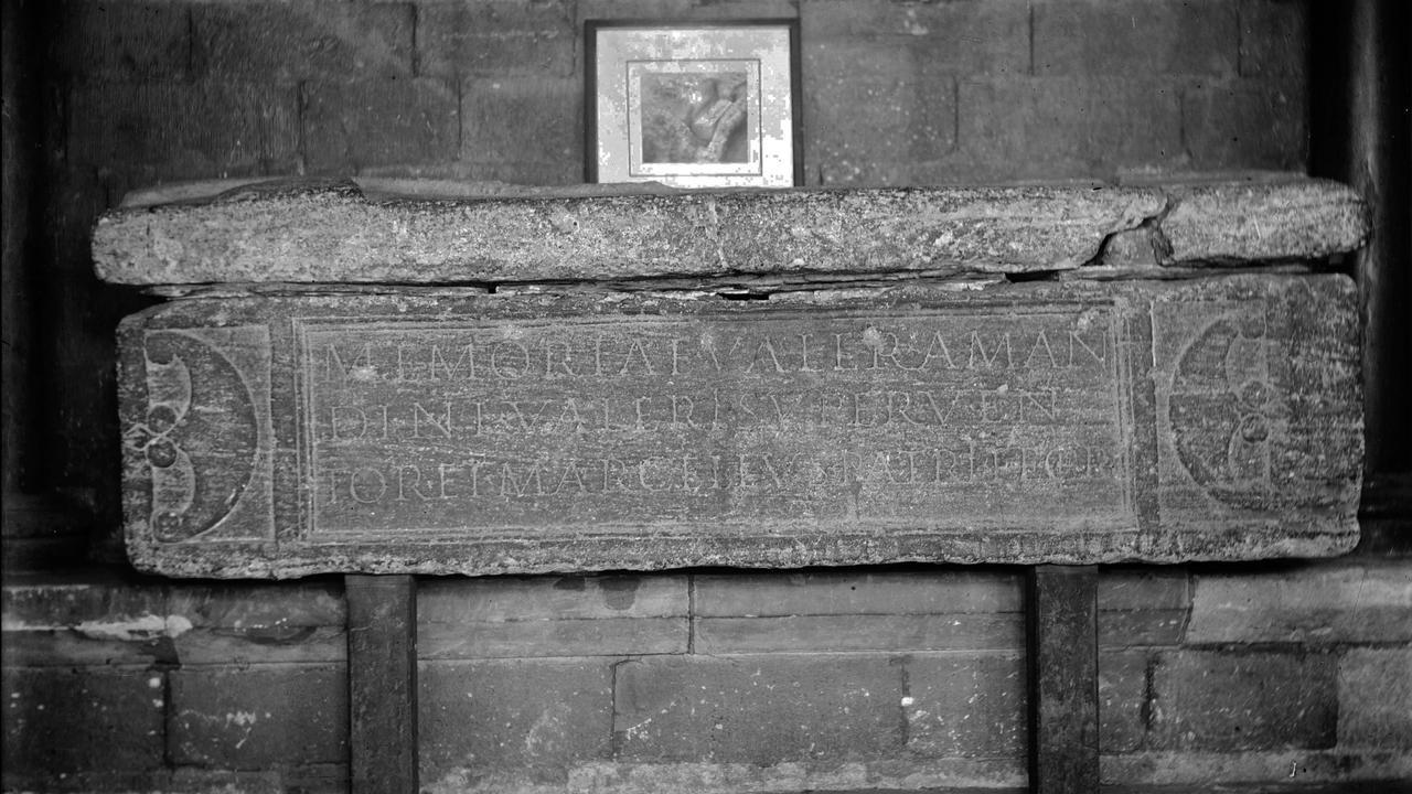 una fotografia in bianco e nero del lato di un sarcofago romano con un’iscrizione