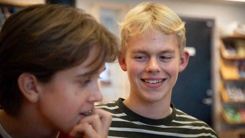 Erling Braut Haaland ha dato il via a una gara di lettura per il comune di Time, dove è cresciuto. Eirik Braut Ueland e Tormod Vetrhus, della decima classe della scuola secondaria di primo grado di Bryne, parlano del premio. Tormod indossa un maglione a righe e sorride con aria furba a Eirik Braut Ueland, che sembra pensieroso.