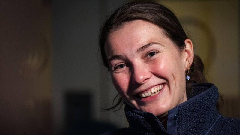 Foto: Mark Tonkin / NRK Ritratto di una donna sorridente con un maglione in pile blu scuro. (La descrizione dell’immagine è stata generata da un servizio di IA)