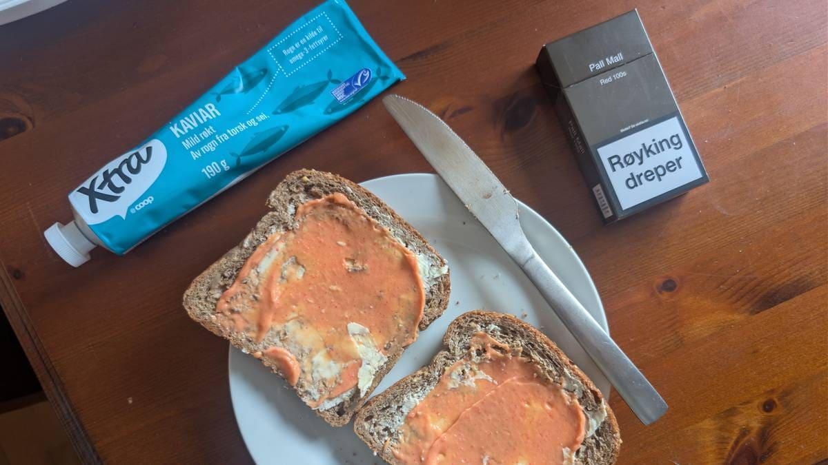 Foto: Kim-Adrian Rasmussen / Privato Due fette di pane con caviale su un piatto, insieme a un tubetto di caviale, un coltello e un pacchetto di sigarette. (La descrizione dell’immagine è stata generata da un servizio di IA)