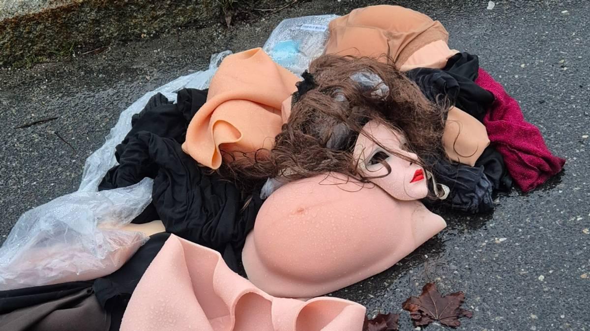 Foto: Privat Una testa di bambola gettata via, protesi mammarie e vestiti sono sparsi su un’area di sosta bagnata. (Descrizione dell’immagine generata da un servizio di IA)