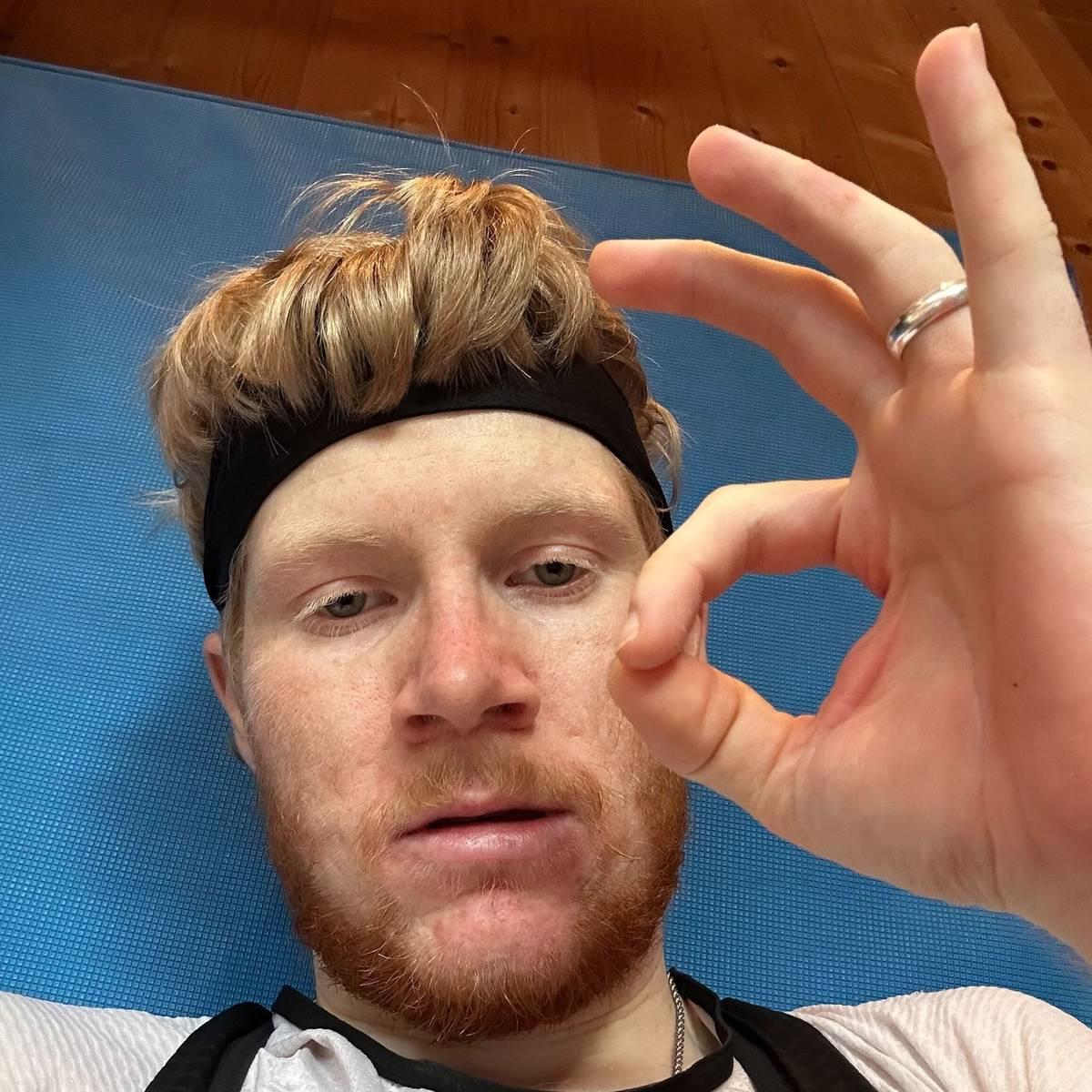 uomo con capelli e barba seduto su una bicicletta al chiuso